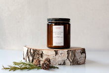 Load image into Gallery viewer, Mistletoe Kisses scented soy wax candle in amber jar with black lid